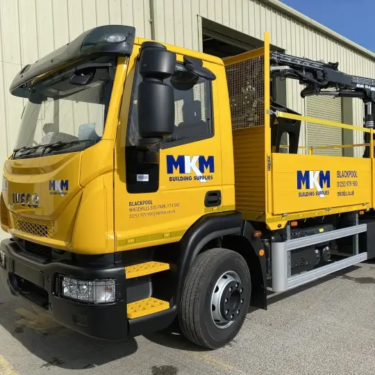 Yellow truck with a claw forklift at the back