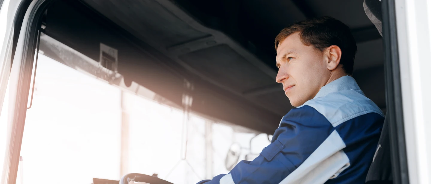 Man sitting in front seat of HGV looking out the window