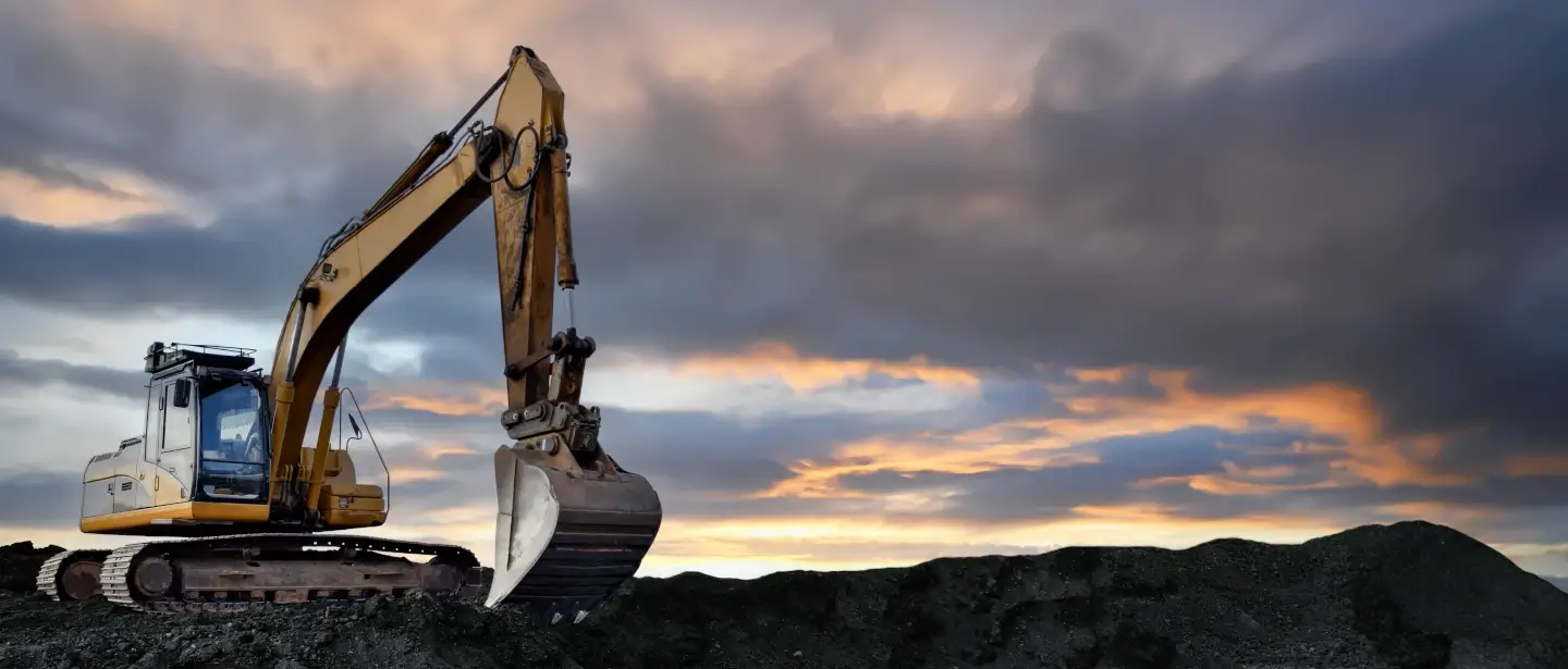 Yellow rotating excavator at a construction site