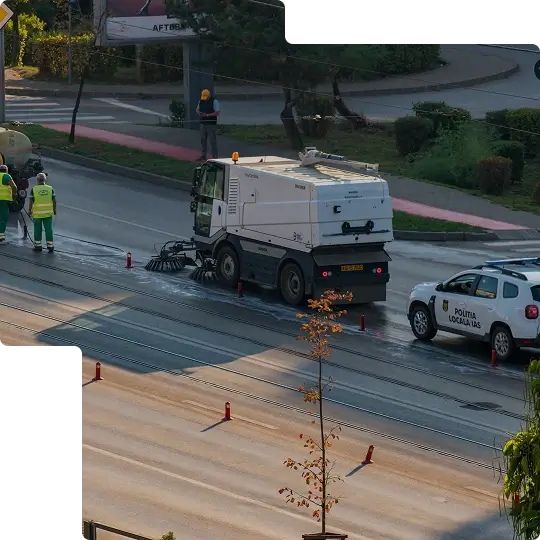 A road sweeper driving down the road, cleaning the road.